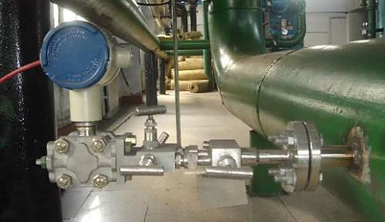 Differential pressure transmitter with three-valve manifold connected to an averaging pitot tube in an insulated process line