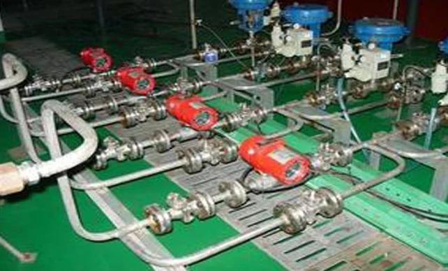 Rows of metering lines with integral flow instruments and control valves on a plant instrument rack
