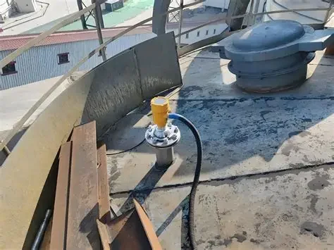Radar level transmitter installed on a short flanged nozzle on a tank roof, with the signal cable run along the deck
