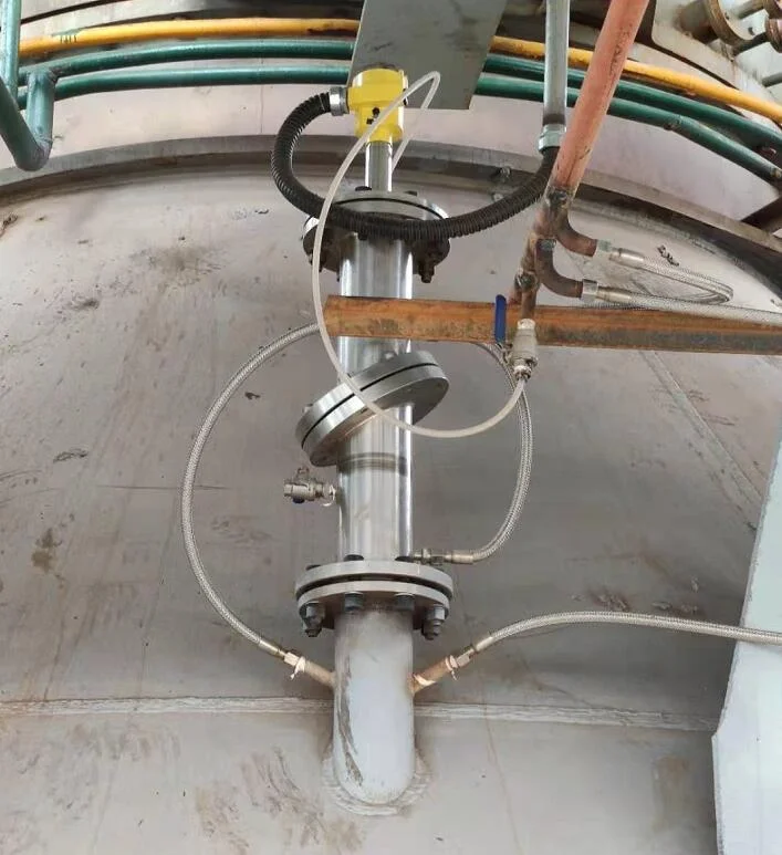 Field installation of a radar level transmitter mounted on a flanged stainless steel stilling pipe on a process vessel
