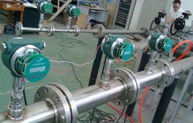 Gas mass flow meters mounted on stainless steel metering lines in a workshop