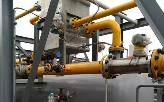 Stainless steel turbine flow meter with transmitter head flanged into the piping of a plant metering skid
