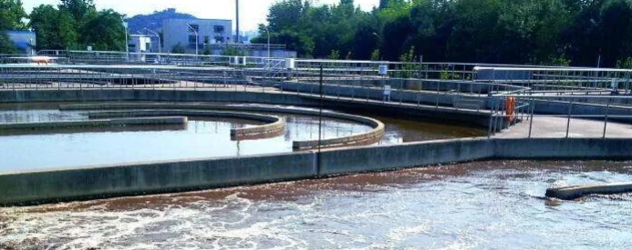 Open water treatment tanks at a plant with walkways and railings