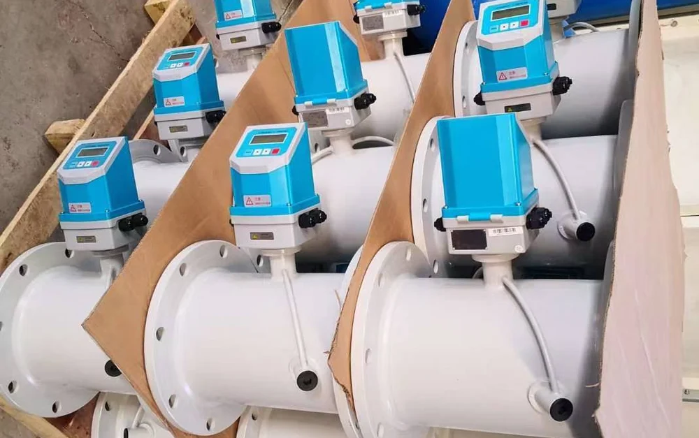 Flanged inline ultrasonic flow meters with mounted converters staged on pallets before shipment