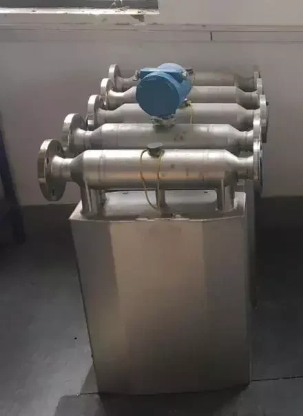 Bent-tube Coriolis mass flow meters with a transmitter head in a workshop