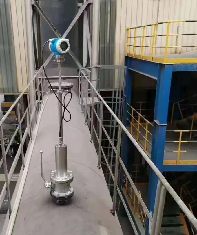 Insertion flow meter mounted through an isolation valve on top of a large process vessel, reached from a catwalk