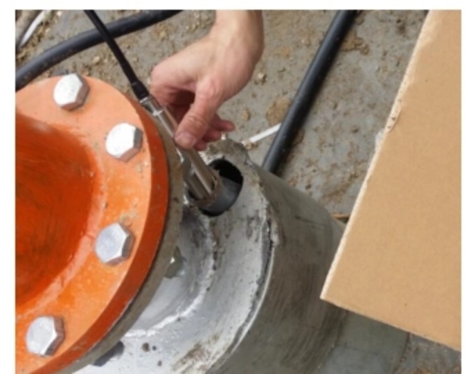Lowering a level sensor probe through the access port of a flanged well head